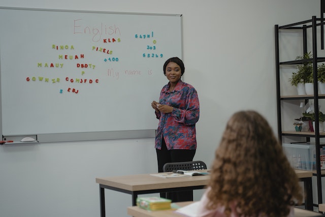 Teacher next to the white board.